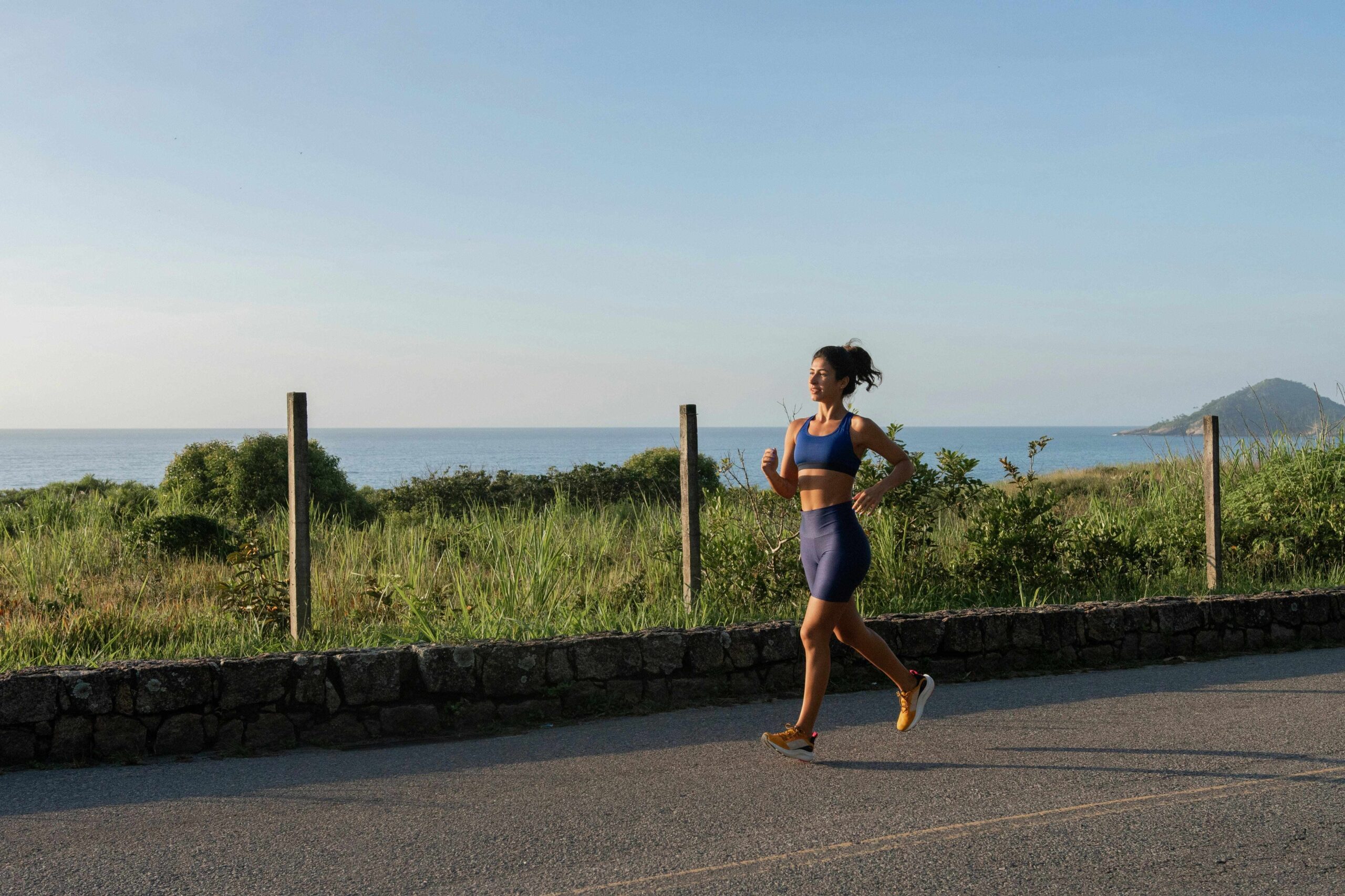 A person running on an open road with a scenic background, showcasing the activity's role in building stamina and cardiovascular health.