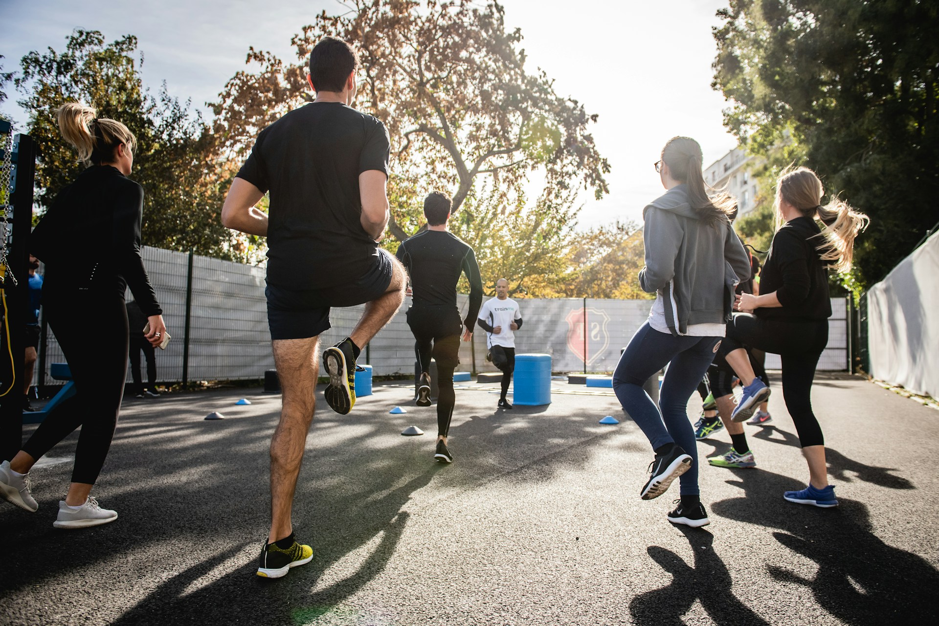 A group of people engaged in different physical activities like running, cycling, and weight lifting, demonstrating how exercise leads to sweating and calorie burn