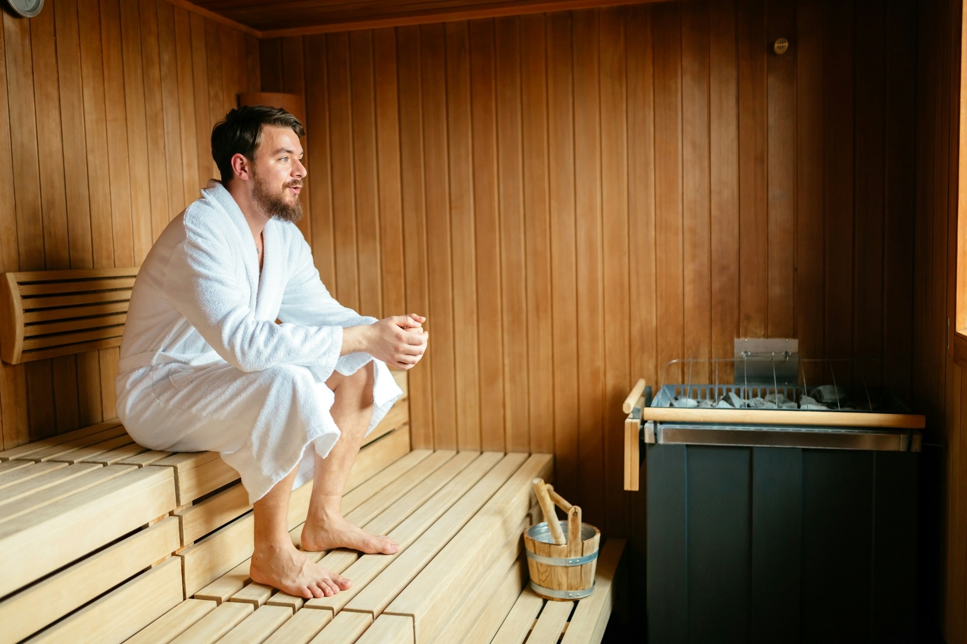 A person sitting in a sauna, illustrating the common misconception that sweating in a sauna can lead to significant calorie burning