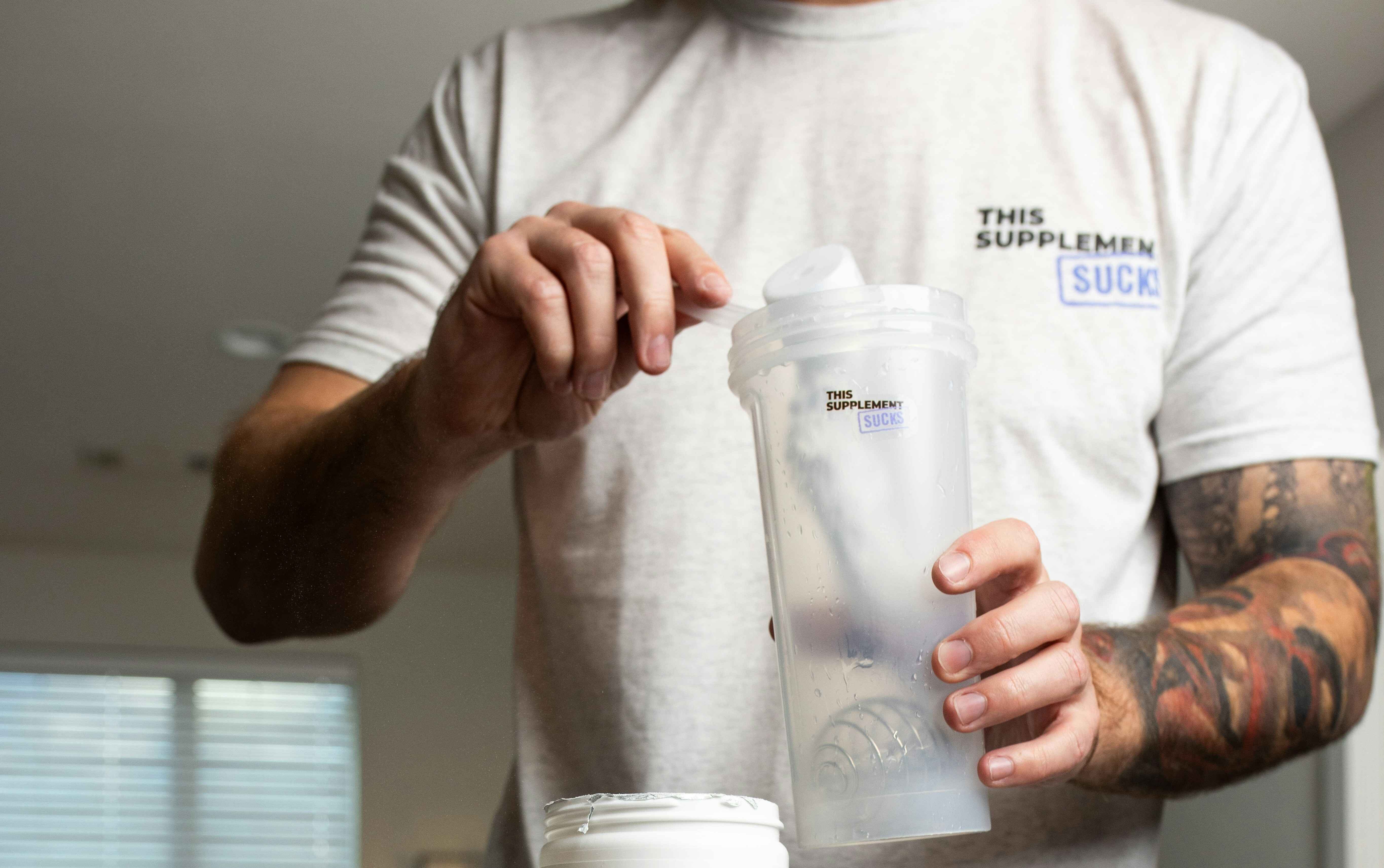 creatine supplement powder with a scoop next to a shaker bottle on a gym bench, representing the importance of timing for optimal creatine intake