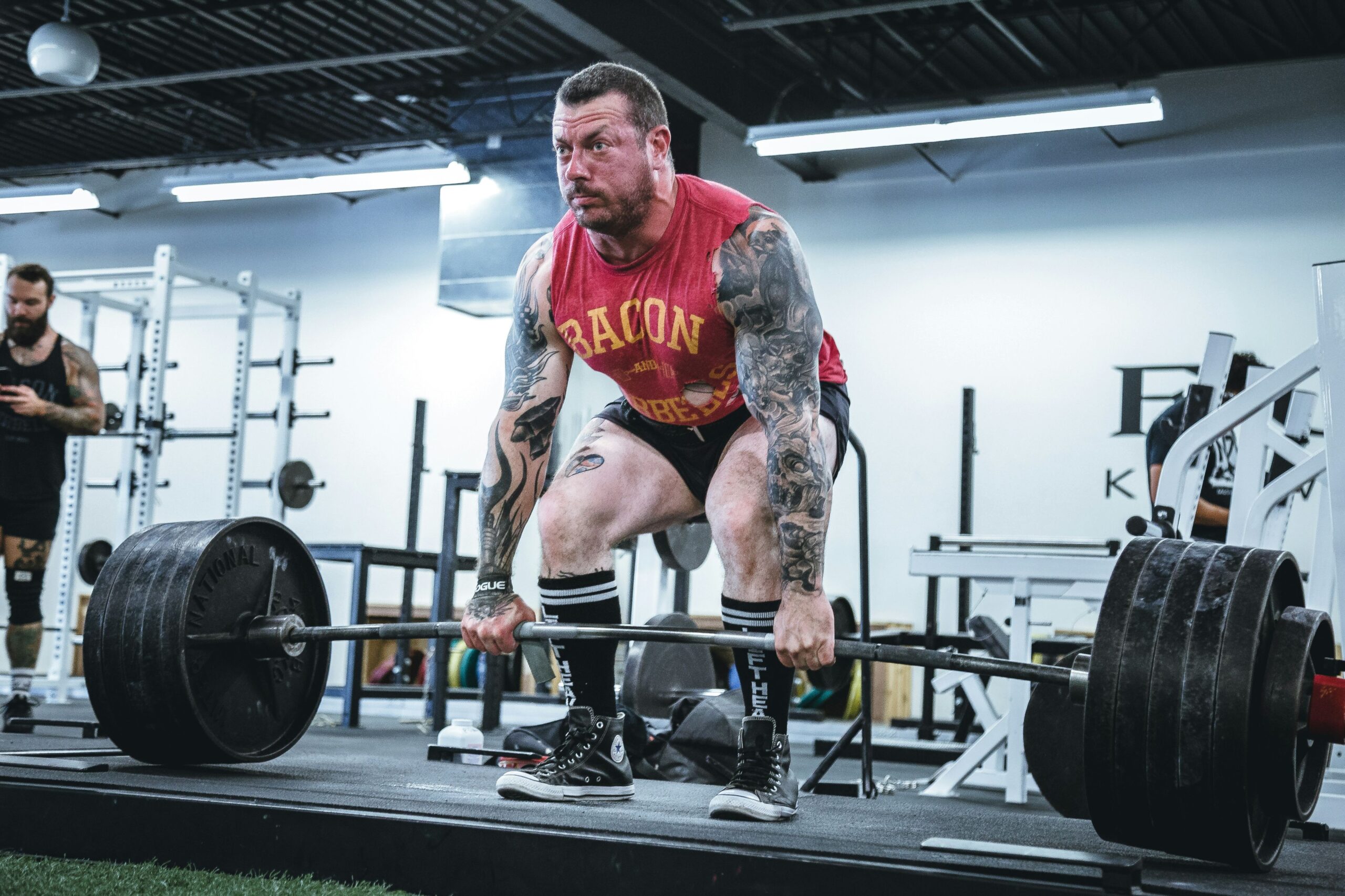 Individual using free weights and cardio machines in a traditional gym, illustrating the flexibility and customizability of traditional gym workouts