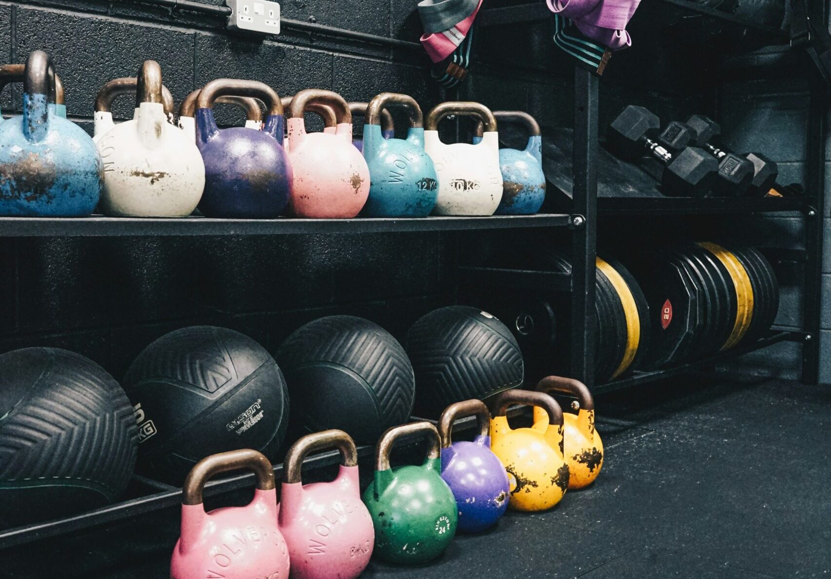 CrossFit gym setup with various equipment like barbells, kettlebells, and ropes, ready for a high-intensity workout.