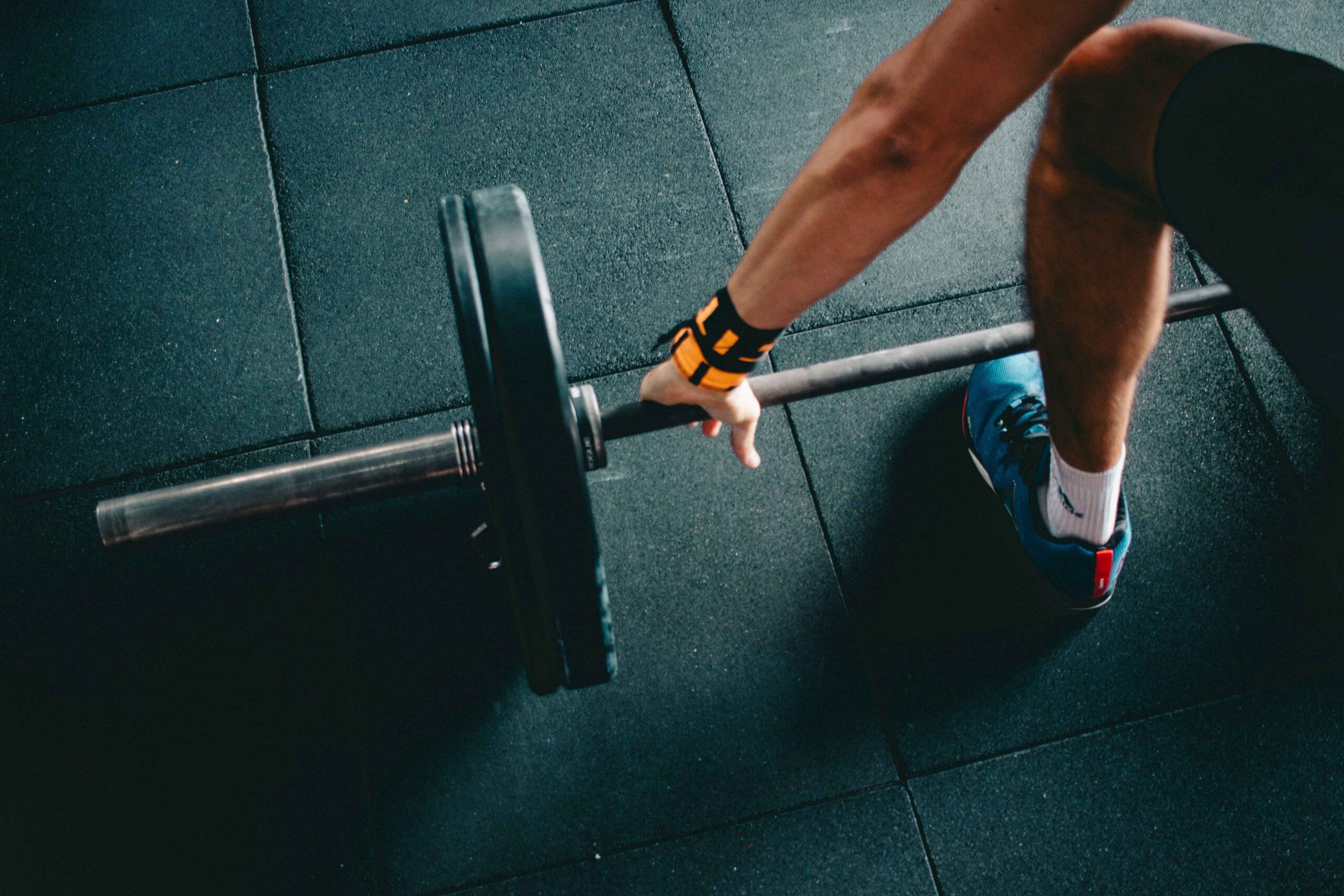 Fitness enthusiast executing a Romanian deadlift with a barbell, emphasizing hamstrings and glute development